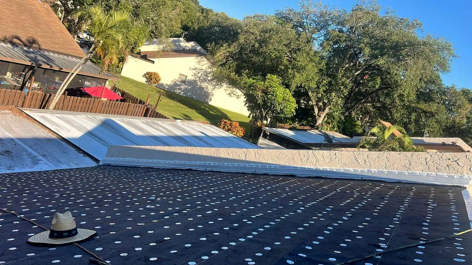 A flat roof dried in with cap-nailed underlayment along a parapet wall
